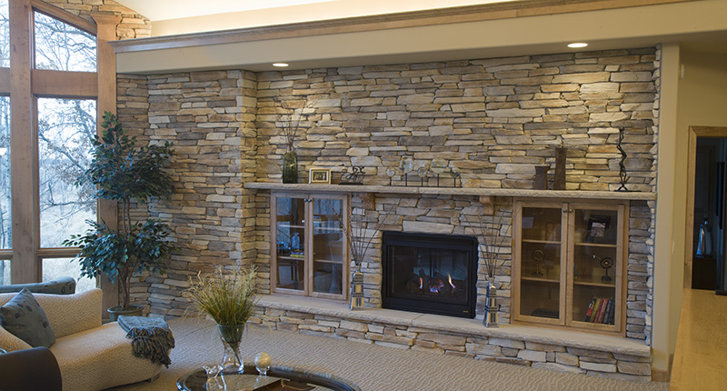 Suede gray montana ledge stone full wall mantle with black gas fireplace insert and built in shelve and mantel